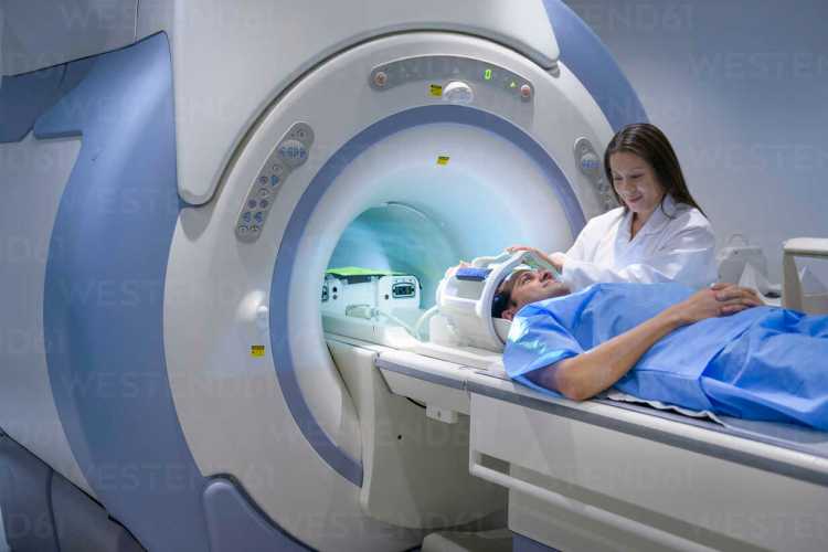 Doctor and patient using Magnetic Resonance Imaging (MRI) scanner stock photo